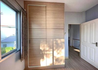 Bright bedroom with large wardrobe and scenic window view