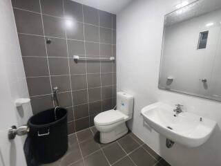 Modern bathroom interior with neutral toned tiles and essential fixtures