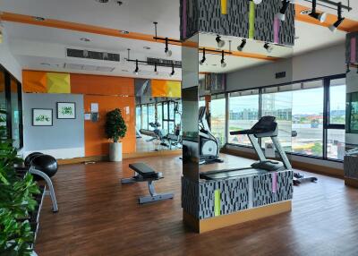 Modern gym facility in a residential building with fitness equipment and large windows