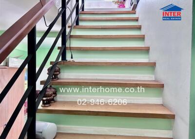 Staircase with neutral color stairs and black handrails