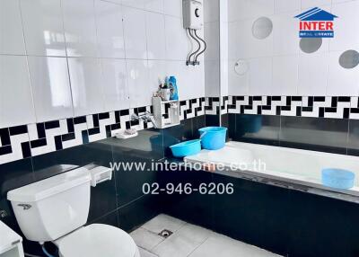 Modern bathroom with black and white tiles, and essential fixtures
