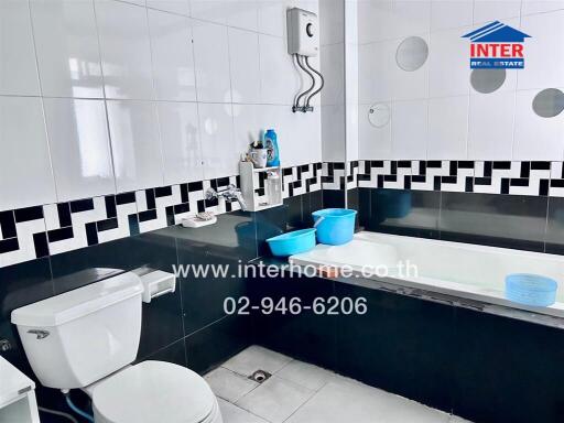 Modern bathroom with black and white tiles, and essential fixtures