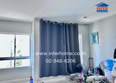 Spacious bedroom with large windows and navy blue curtains