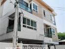 Modern three-story residential building with covered parking space