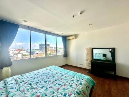 Spacious bedroom with large windows and city view