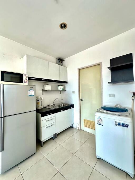 Compact and modern kitchen with white cabinetry and essential appliances