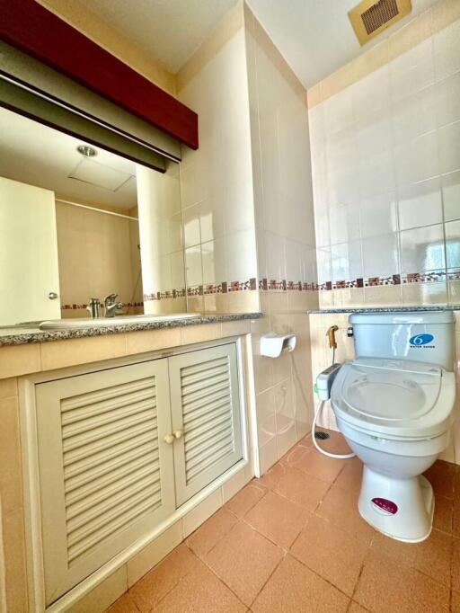 Bright and clean bathroom with under-sink cabinet and tiled walls