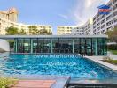 Modern residential building with a large pool and glass-walled common area