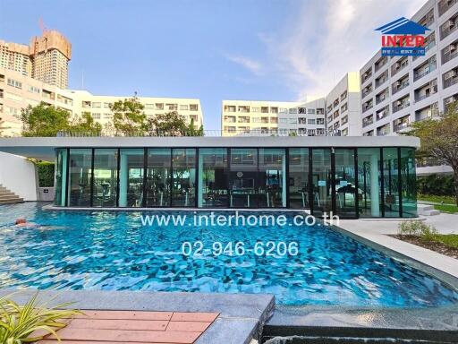 Modern residential building with a large pool and glass-walled common area