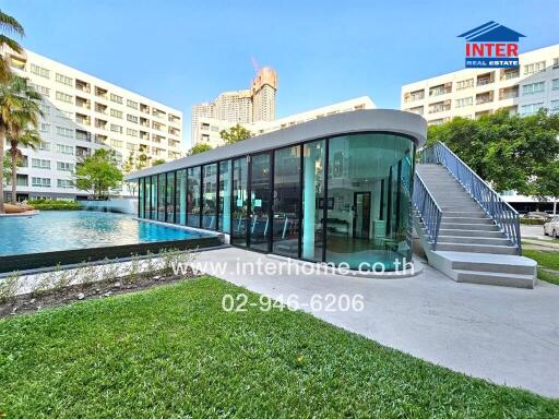 Modern poolside clubhouse with large windows surrounded by residential buildings