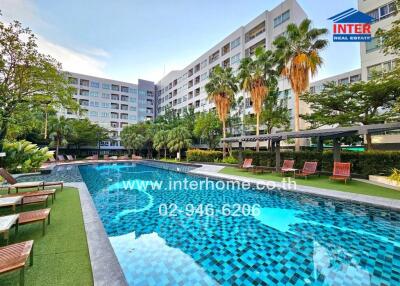 Luxurious condominium complex with a large swimming pool and lush green area