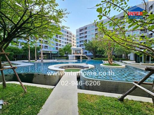 Luxurious outdoor swimming pool surrounded by lush greenery and modern residential buildings