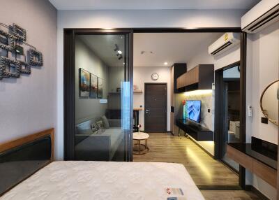 Modern bedroom with view into the living room, showcasing interior design and compact layout