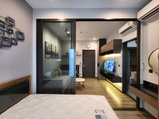 Modern bedroom with view into the living room, showcasing interior design and compact layout