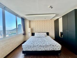 Spacious bedroom with large windows offering a city view