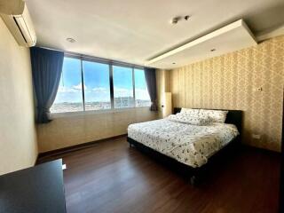 Spacious bedroom with large windows and city view