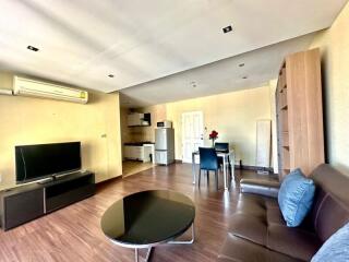 Spacious and well-lit living room with integrated kitchen area