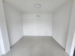 Spacious and empty living room with white walls and gray flooring