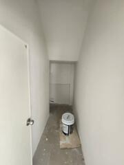 Narrow corridor during renovation with white walls and construction materials