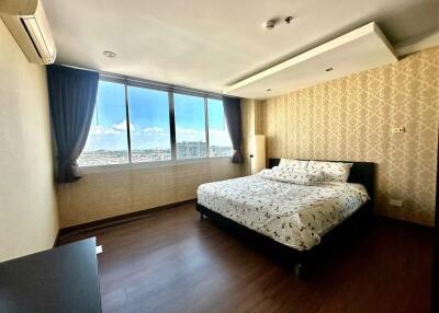 Spacious bedroom with large windows and city view