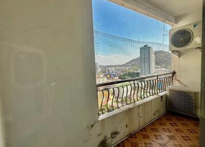 Urban view from a balcony featuring a protective net and cityscape background