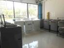 Spacious and Bright Laundry Room with Large Windows and Multiple Machines