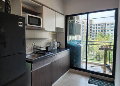 Modern kitchen with appliances and balcony access in an apartment