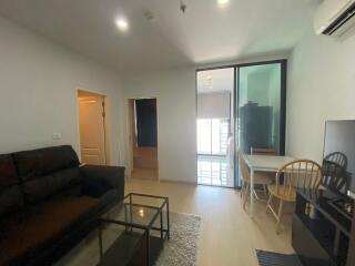 Spacious and well-lit living room with modern furnishings and balcony access