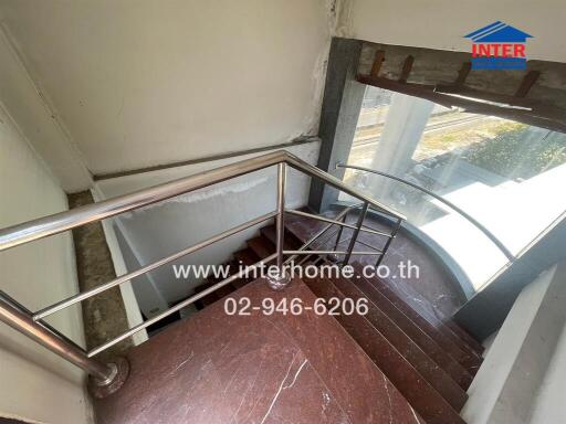 Well-lit staircase with stainless steel railing in a residential building