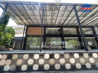 Modern commercial building with large glass windows and shaded outdoor area