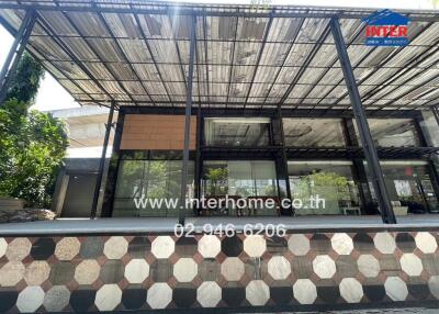 Modern commercial building with large glass windows and shaded outdoor area