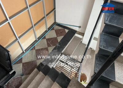 Entrance area with tiled stairs and glass wall