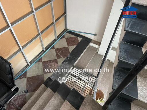 Entrance area with tiled stairs and glass wall