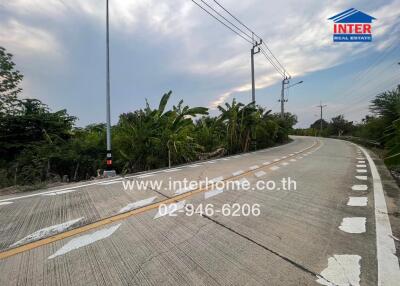 Scenic road leading to a residential area with lush greenery
