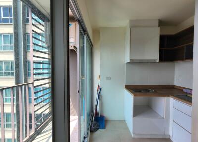 Compact kitchen space with balcony view in a high-rise apartment