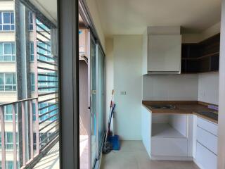 Compact kitchen space with balcony view in a high-rise apartment