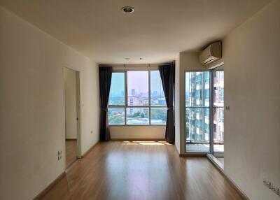 Spacious living room with large windows and city view