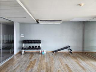 Modern home gym room with wooden floors and essential equipment
