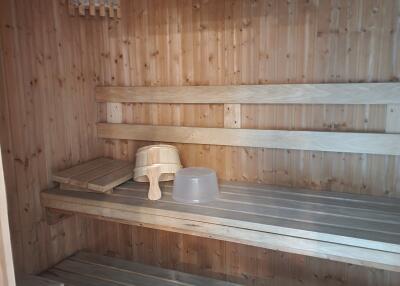 Interior of a wooden sauna room with benches and sauna accessories