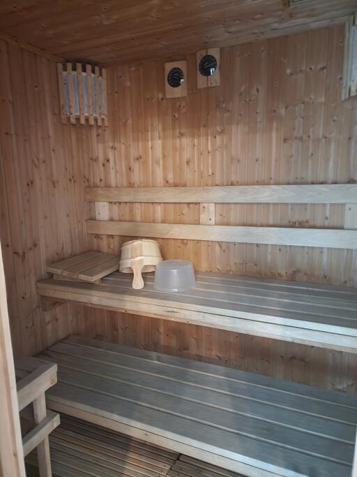 Interior of a wooden sauna room with benches and sauna accessories