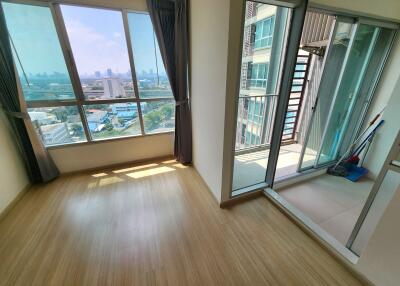 Empty bedroom with large windows and balcony access in a high-rise apartment