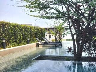 Luxurious outdoor pool with sun loungers and lush greenery