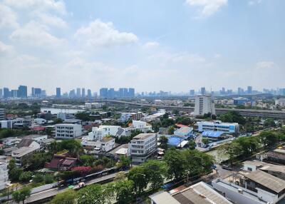 Cityscape view from high-rise building showing a dense urban area under clear blue skies