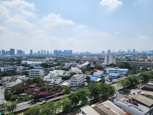 Cityscape view from high-rise building showing a dense urban area under clear blue skies