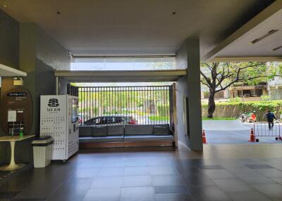 Spacious and well-lit building entrance with seating area and security gate