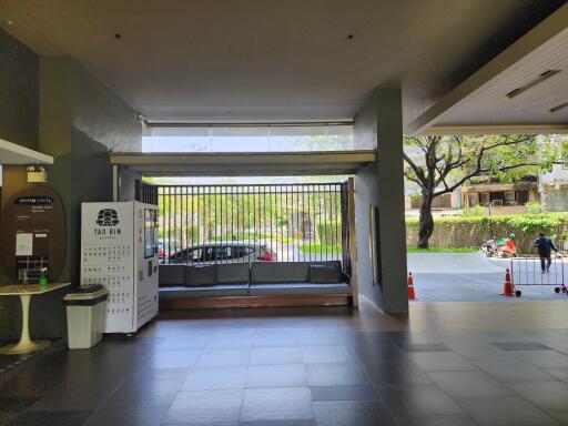 Spacious and well-lit building entrance with seating area and security gate