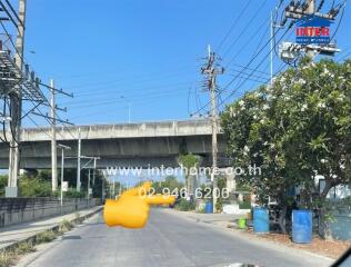 Urban street scene with elevated train track and greenery