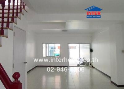 Spacious and brightly lit living space with staircase leading to upper floor