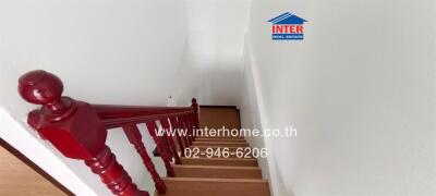 Bright and clean staircase with elegant red railing in a residential building