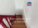 Bright and clean staircase with elegant red railing in a residential building